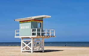 A lifeguard tower labeled "DEAUVILLE" on a beach with a clear blue sky and calm sea. - Superbe bâtisse à colombage (Saint-Etienne-la-Thill)
