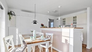 A modern kitchen with white cabinetry, a central island, and pendant lighting. - Amazing home in Brenderup Fyn with sauna (Brenderup Fyn)