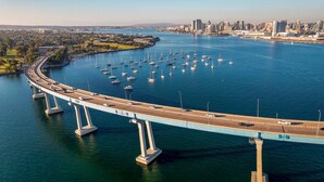 Un pont comportant plusieurs voies de circulation et sur lequel on peut voir plusieurs bateaux sur l’eau.