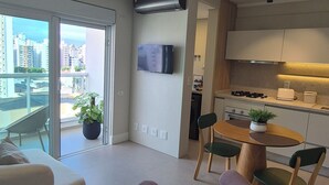 A modern apartment with a balcony, a dining area, and a kitchen. - eStudio Central 506 (Florianópolis)