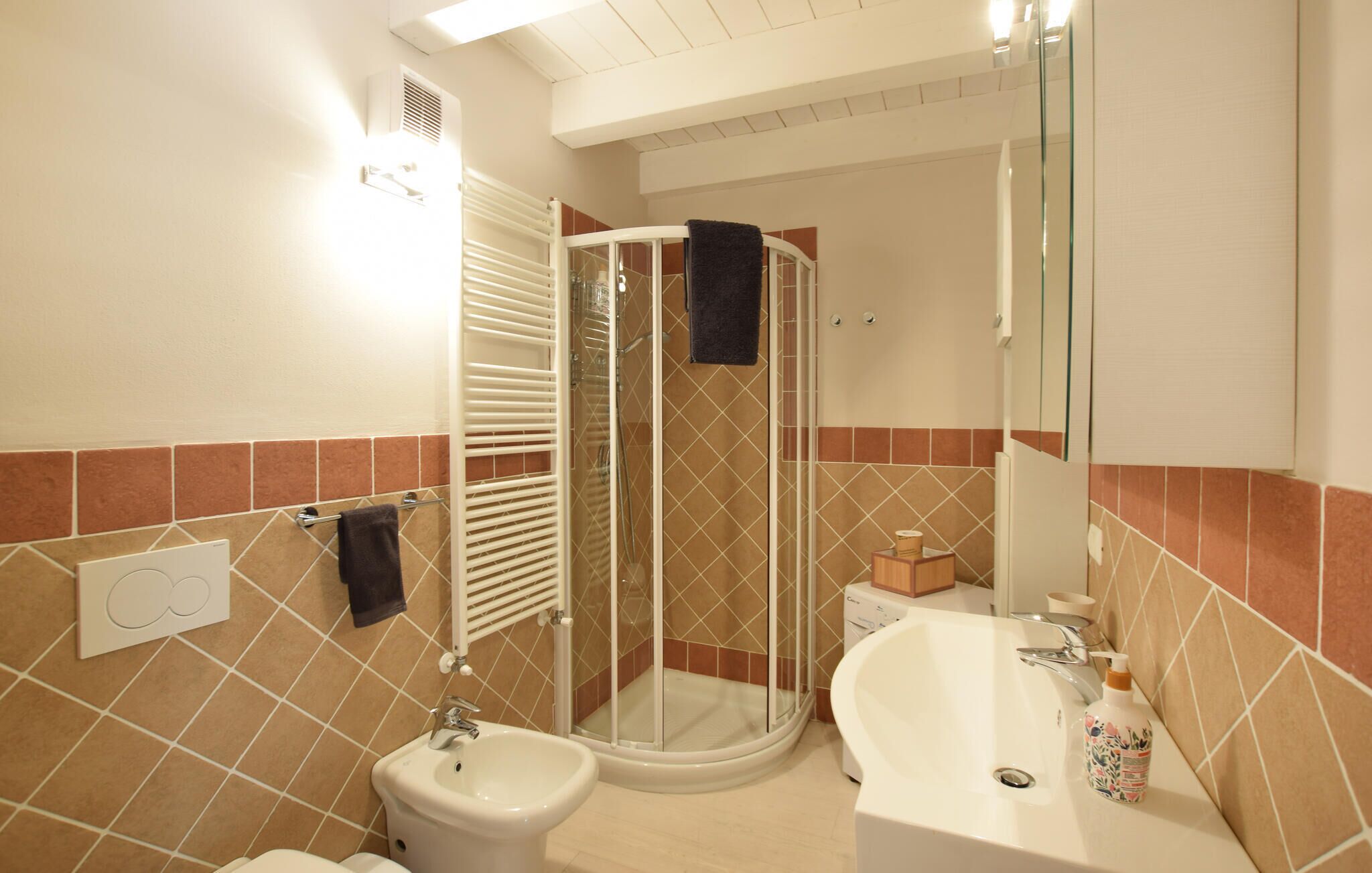 A bathroom with a glass-enclosed shower, a sink, and a toilet.