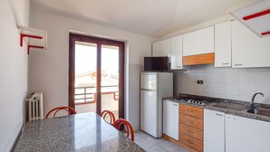 A kitchen with a granite countertop, white cabinets, a refrigerator, and a microwave. - 1 bedroom gorgeous apartment in Briatico (Briatico)
