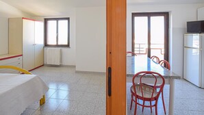 A room with a bed, a desk, a chair, a radiator, and a window. - 1 bedroom gorgeous apartment in Briatico (Briatico)