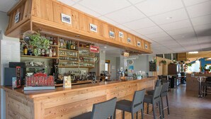 A bar area with wooden counters and wicker chairs, shelves with bottles and glasses, and a sign reading "DESPERADOS". - Studio for 4 to 5 people, "Edelweiss" with mountain view balcony (Le Biot)