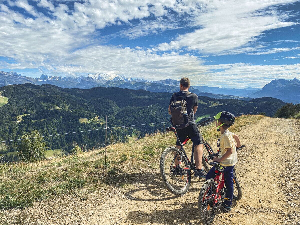 A mountain biking trail with a view of distant mountains and a clear sky.