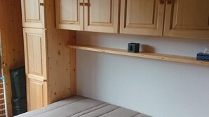 A room with a bed, wooden cabinets, and a shelf. - Studio for 4 to 5 people, "Edelweiss" with mountain view balcony (Le Biot)