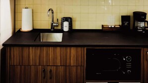 Une cuisine moderne équipée d’un évier, d’une machine à café et d’un lave-vaisselle.