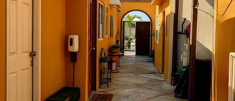 A corridor with a tiled floor, benches, a door, and a window.