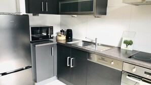 Uma cozinha moderna com eletrodomésticos de aço inoxidável, incluindo geladeira, micro-ondas e forno.
