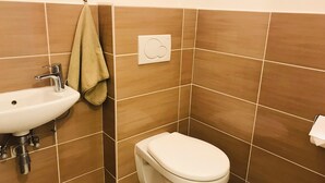 Casa de banho com lavatório, sanita e suporte para toalhas.