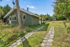 Una casa a un piano con un vialetto in pietra che conduce all'ingresso.