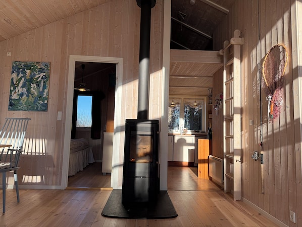 Ein Holzinterieur mit Kamin, Essbereich und Küche.
