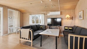 Un salon confortable avec un canapé, une table basse et un téléviseur.