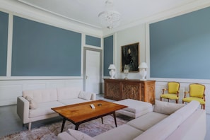 A living room with a sofa, a coffee table, a cabinet, and two chairs.