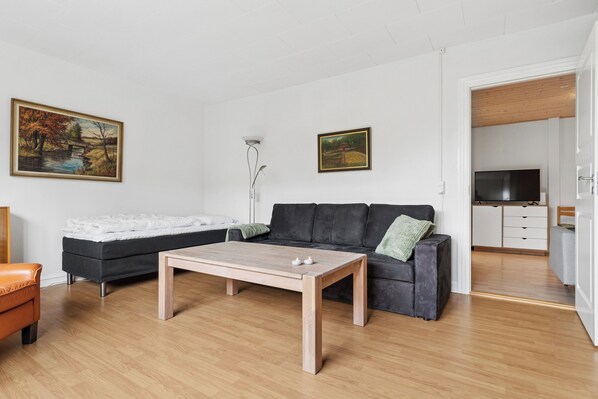 Una sala moderna con un sofá modular, una mesa de centro y dos cuadros en la pared.
