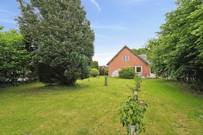 A brick house with a well-maintained lawn and large trees. - The coziest farm holiday in the countryside (Tommerup)