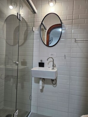 Chuveiro, toalhas de banho, sabonete, papel higiênico