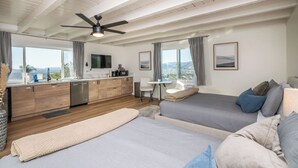 Un dormitorio moderno con una cama grande, un escritorio y vistas a las montañas.