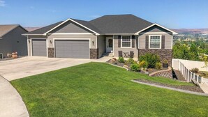 A single-story house with a garage, a well-maintained lawn, and a view of the surrounding landscape. - Perfect 3-bedroom house with Gorgeous Views in Selah (Selah)