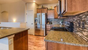 A modern kitchen with granite countertops, stainless steel appliances, and a brick backsplash. - Perfect 3-bedroom house with Gorgeous Views in Selah (Selah)