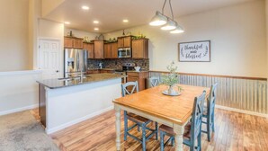 A kitchen with wooden cabinets, stainless steel appliances, and a wooden dining table with chairs. - Perfect 3-bedroom house with Gorgeous Views in Selah (Selah)