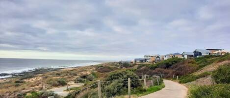 A coastal residential area with houses on a hillside overlooking the sea.