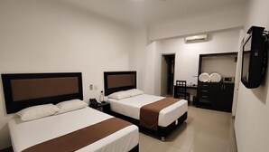 A hotel room with two beds, a desk, a chair, a wardrobe, and a television. - Hotel Win & Win (Piura)