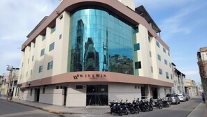 A hotel with a curved facade, large reflective windows, and a sign reading "WIN&WIN HOTEL". - Hotel Win & Win (Piura)