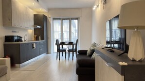 Una cocina moderna con comedor, sofá y televisor.