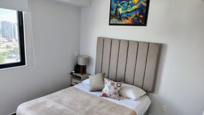 Una camera da letto con un letto, un comodino, una lampada e un quadro appeso al muro.