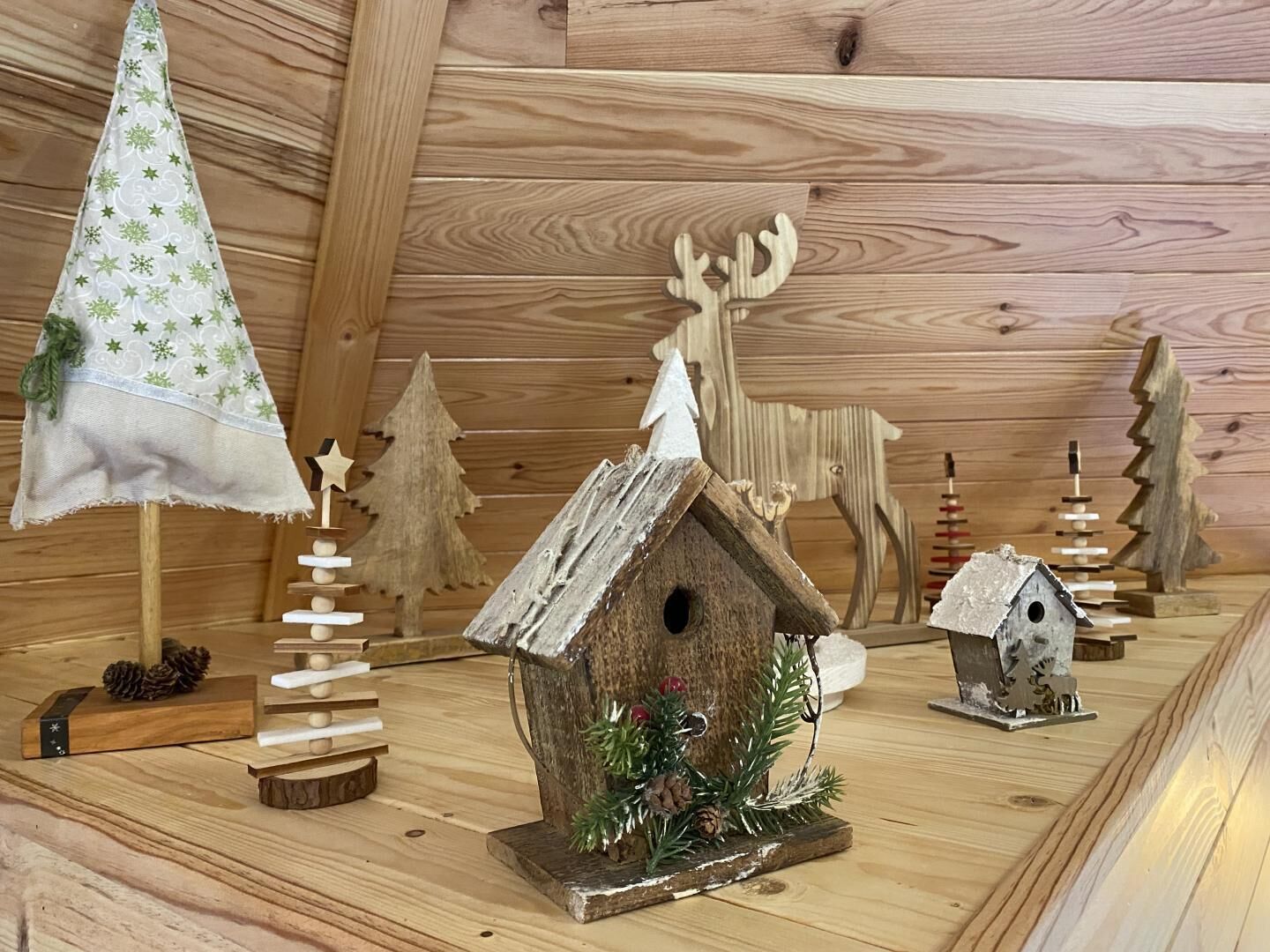 A collection of wooden Christmas decorations including a tree, a reindeer, and birdhouses.