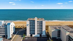 Ett hotell vid stranden med en parkeringsplats och utsikt över havet.