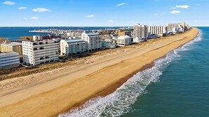 Een kusthotel met meerdere gebouwen aan het strand, met een zandstrand en uitzicht op zee.