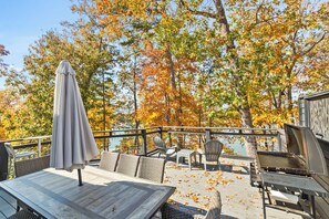 An outdoor patio with a table, chairs, and a grill. - Hartwell Haus with Dock & Playground (Fair Play)