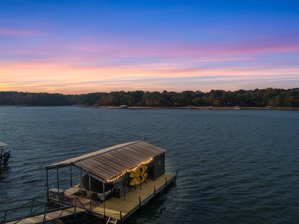 A floating structure with a covered area and a boat docked nearby. - Hartwell Haus with Dock & Playground (Fair Play)