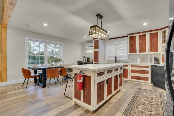 Une cuisine moderne dotée d’un îlot central, de meubles en bois et d’un lave-vaisselle encastré.
