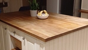 A kitchen with a wooden countertop, a potted plant, and a bowl of fruit. - Park Cottage Bed & Breakfast near Burtonwood (Saint Helens)