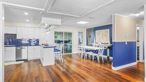 Une cuisine moderne avec des armoires blanches, un dosseret en carreaux bleus et un plancher en bois.