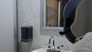 Ein Badezimmer mit einem weißen Waschbecken, einem Spiegel und einem Fenster.