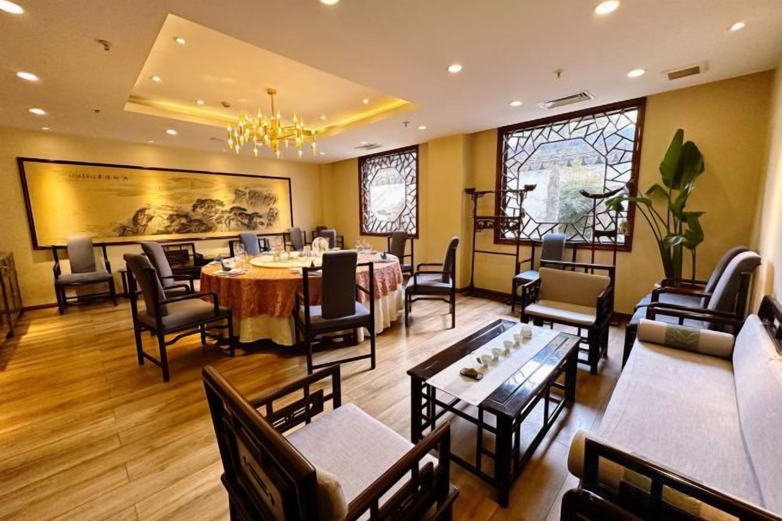 Uma sala de jantar tradicional com móveis de madeira, um candelabro e uma grande janela com vista.