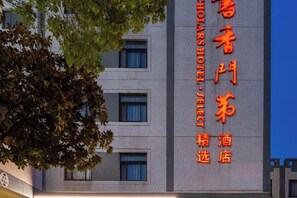 Un letrero de hotel con caracteres chinos y el nombre 'HOLABAR HOTEL' en inglés.