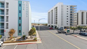 A multi-story building named 'FOURS SEASONS' with a parking lot in front. - Angelfish 207 (Ocean City)
