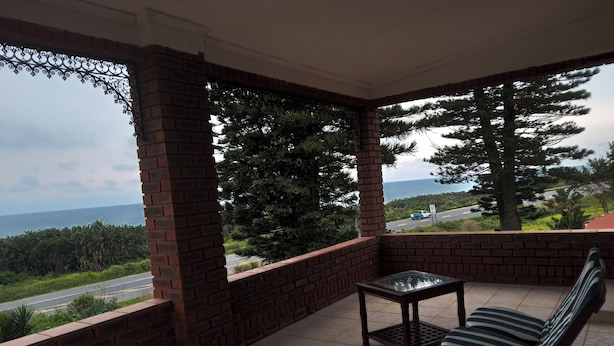 A balcony with a view of the ocean and a road.