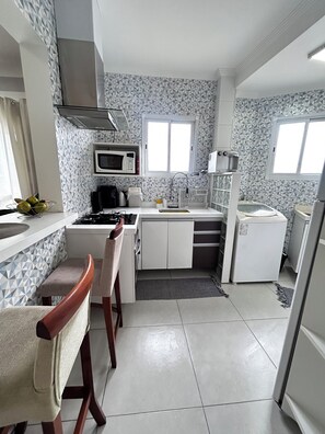 Fridge, microwave, oven, stovetop - Modern apartment in Praia Grande, 500m from the beach, with air conditioning, garage, and Wi-Fi. (Praia Grande)