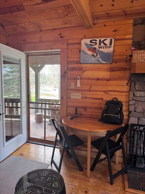 A wooden interior with a table, chairs, a fireplace, and a sign reading 'SKI WISP'.