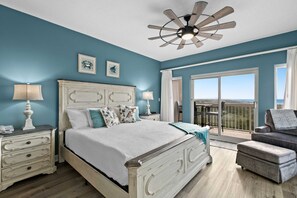 A bedroom with a bed, bedside tables, a ceiling fan, and a balcony with a view. - 1BR oceanview studio with private balcony (Miramar Beach)