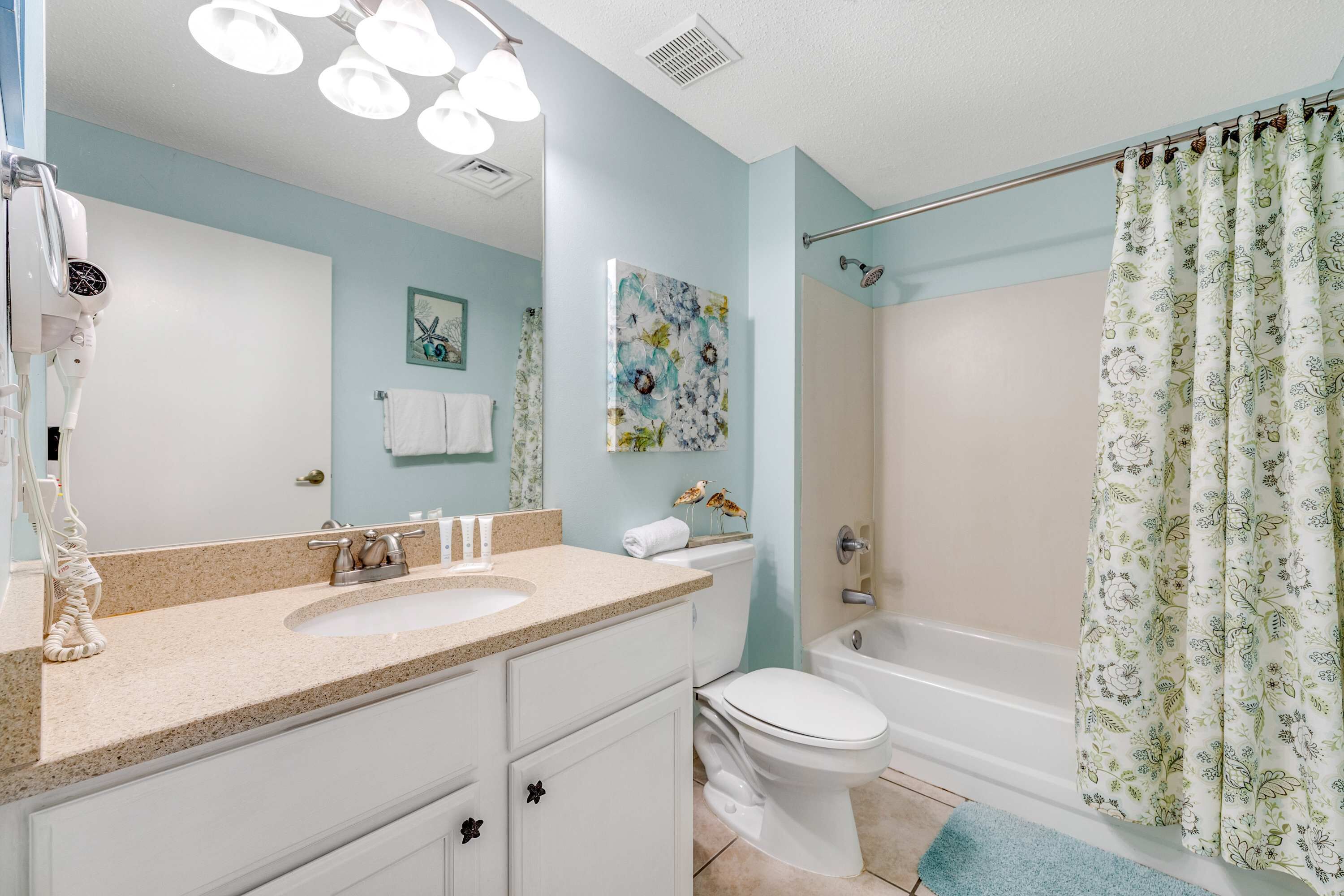 Une salle de bain avec un lavabo, des toilettes et une douche.