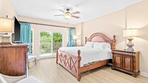 A bedroom with a bed, a desk, a chair, a wardrobe, and a ceiling fan. - 1BR condo steps to beach, pools, hot tub (Miramar Beach)