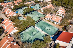 An aerial view of a residential area with multiple tennis courts surrounded by houses with red roofs. - 1BR condo steps to beach, pools, hot tub (Miramar Beach)