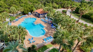 An aerial view of a resort with a pool, lounge chairs, and palm trees. - Luxury condo w/private balcony & resort access (Miramar Beach)